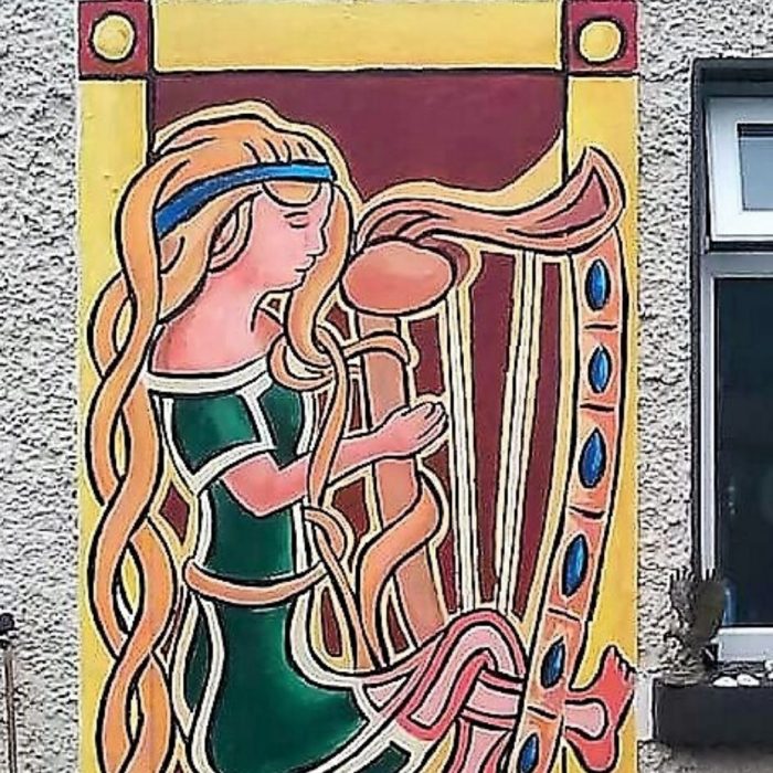 Mural of an Irish dancer playing the harp on a building, Ireland by Artist David O'Rourke